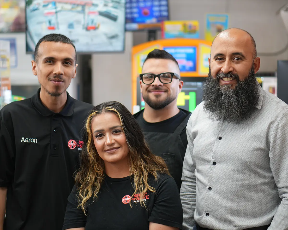 Taha Saleh with employees at Shop N Save Market in Porterville.